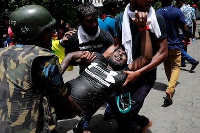 En una comparecencia televisiva y después de que la protesta irrumpiera en las oficinas de la jefatura de gobierno, Wickremesinghe ha instado a las fuerzas de seguridad del país a hacer lo necesario para “restaurar el orden” y acabar con la “amenaza fascista” a raíz de la fuerte ola de protestas registradas en el país. En la foto, manifestantes llevan a un hombre herido, este miércoles.