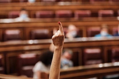 Una mano marca el sentido de una votación en el Congreso de los Diputados.