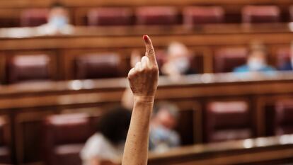 Una diputada marca, con su dedo, el sentido del voto de su partido en el Congreso de los Diputados.