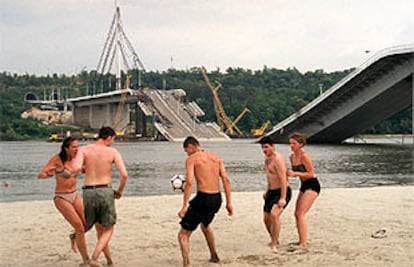 Chicos y chicas serbios juegan al fútbol en Novi Sad, a orillas del Danubio y junto al puente Sloboda, destruido por la OTAN.
