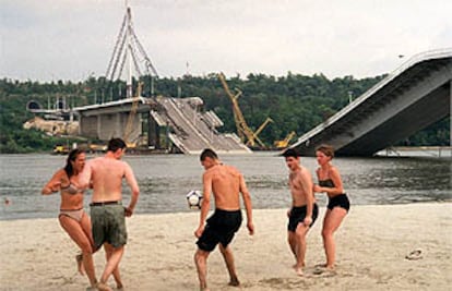 Chicos y chicas serbios juegan al fútbol en Novi Sad, a orillas del  Danubio y junto al puente Sloboda, destruido por la OTAN.