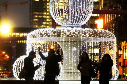 Un grupo de jóvenes ante una fuente con iluminación navideña en el centro de Frankfurt. La ciudad alemana acoge cada año uno de los mercadillos de adviento con mayor tradición de Alemania, que fue inaugurado el pasado 23 de noviembre.