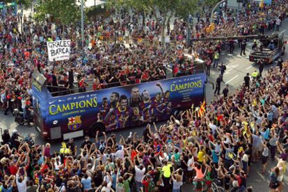 Los jugadores del Barcelona, aclamados por miles de aficionados en su recorrido por las calles de la capital catalana.
