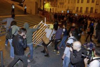 Manifestantes tratan de tumbar una barrera durante una manifestación por el presupuesto presentado ayer por el Gobierno ante el Parlamento en Lisboa (Portugal).