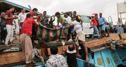 Varios yemen&iacute;es recogen un cad&aacute;ver de un migrante somal&iacute;, en marzo en el puerto de Hodeida.