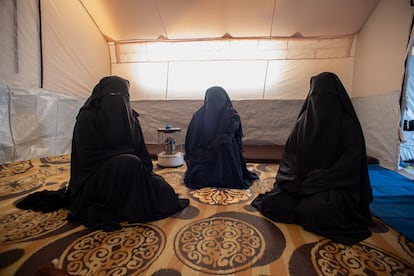 La siria Meriem Hajar, de 23 años, se sienta entre sus dos hermanas en el interior de su tienda en un campo de Al Hol.