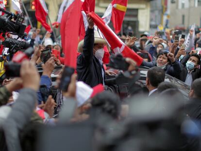 The presidential candidate for the Peru Libre party, leftist Pedro Castillo, flutters a national flag as he arrives at the party's headquarters in Lima on June 7, 2021, a day after runoff elections. - Right-wing populist Keiko Fujimori held a narrow lead Monday in Peru's presidential election, but the crisis-hit nation's race was too close to call as votes were still being tabulated from countryside bastions of support for radical leftist Pedro Castillo. With over 95% of the votes tallied, the result of the runoff election is still unknown. (Photo by Luka GONZALES / AFP)
