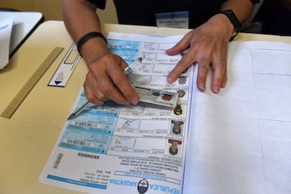 Un miembro de una mesa electoral confirma la identidad de un votante, el 22 de octubre, en Buenos Aires.