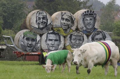 Rollos de heno con los retratos de ciclistas campeones de ediciones anteriores del Tour de Francia en un prado del recorrido de la quinta etapa entre Ypres y Arenberg-Porte du Hainaut.