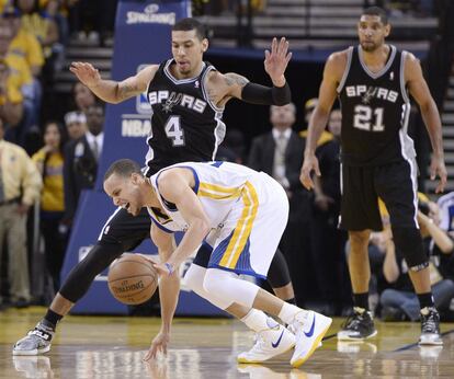 Curry, de los Warriors, se duele ante Green y Duncan, de los Spurs.