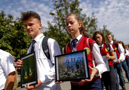 Estudiantes albanokosovares sostienen fotografías de las Torres Gemelas de Nueva York durante una marcha con motivo del 17 aniversario de los atentados de 2001, en Pristina (Kosovo).