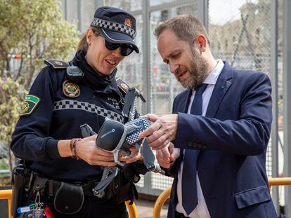 El concejal de Seguridad de Valencia, Aarón Cano, y una agente de la Policia Local sujetan uno de los drones que vigilarán desde el aire la plaza del Ayuntamiento.