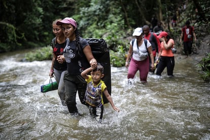 Una familia migrante cruza un río en la selva del Darién, en mayo de 2023.  