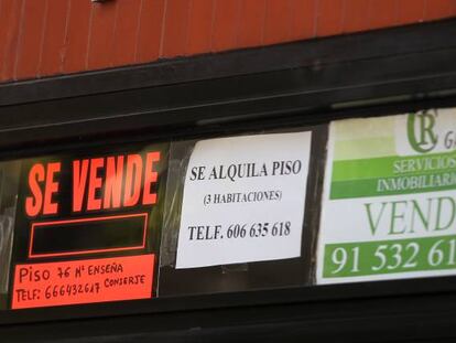 Carteles de Se Vende y Se alquila en un portal de viviendas.