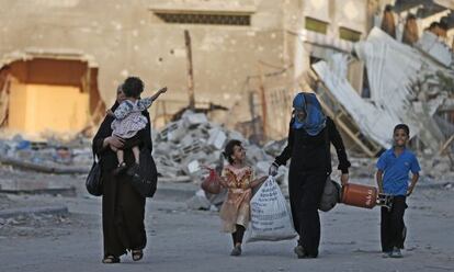 Palestinos caminham para um abrigo da ONU, em Gaza.