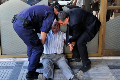 Aposentado se desespera diante de fila em agência bancária em Atenas.
