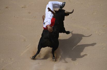 Uno de los recortadores salta por encima de un morlaco negro, en la plaza de toros de Pamploa durante el Concurso Nacional de Recortadores.