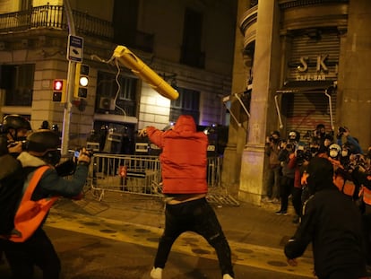 Un manifestante tira un objeto hacia las fuerzas de seguridad, este domingo en Barcelona.