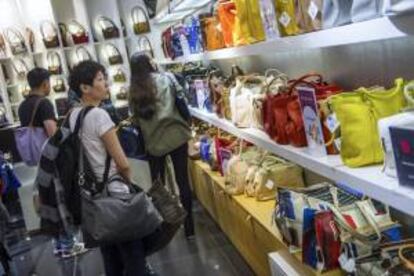 Una mujer observa una colección de bolsos en las Galerías Lafayette en París. EFE/Archivo