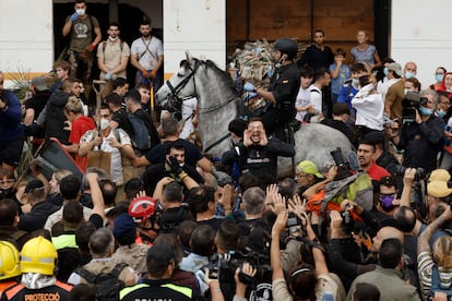 Un agente de la Policía montada tratan de poner calma entre los vecinos indignados, este domingo en Paiporta.