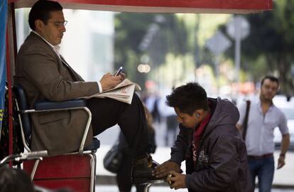 Un limpiador de zapatos y su cliente en el DF. 