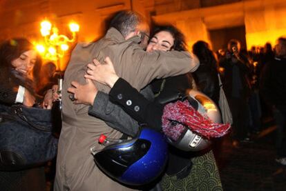 Dos italianos celebran la marcha de Berlusconi a las puertas del palacio presidencial, en Roma.