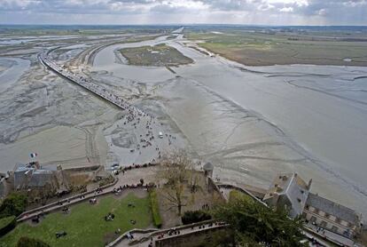 Vista desde la abadía gótica del Monte Saint-Michel de la gente que espera la 'marea del siglo'. Se calcula que en este punto de la costa francesa, el agua puede subir 14,15 metros.