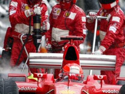 Los operarios de Ferrari revisan el coche de Michael Schumacher.