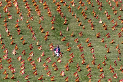 Un hombre hace una fotografía en el Parque de Roma de Madrid, lleno de banderines de España, este domingo.