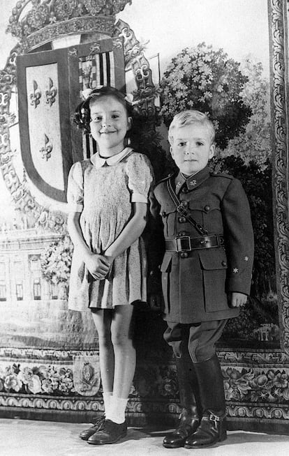 El príncipe Juan Carlos de Borbón posa con el uniforme de capitán de caballería que le han enviado desde España, acompañado de su hermana, la infanta Pilar, en Lausana (Suiza), en mayo de 1942.