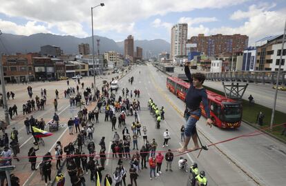 Un estudiante universitario camina sobre una cuerda mientras los manifestantes bloquean una calle durante el paro nacional de este miércoles, en Bogotá.