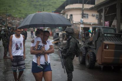 Moradores caminham pela Vila Kennedy durante operação do exército, nesta sexta.