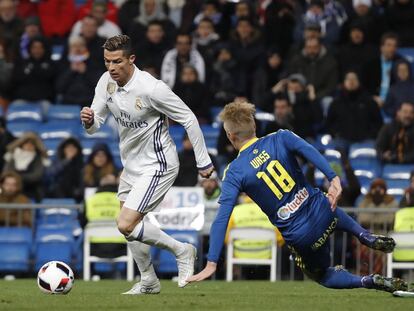 El delantero del Real Madrid Cristiano Ronaldo (i) pelea un balón con el delantero del Celta Daniel Wass.