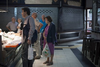 Varias personas comprando en un mercado.