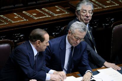 Berlusconi, junto al ministro Tremonti (centro) y Umberto Bossi, ayer en el Parlamento.