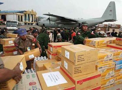 Soldados tailandeses (uniforme marrón) y birmanos (de verde) descargan cajas de comida de un avión enviado por el Gobierno tailandés a Yangon.