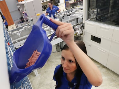 Una trabajadora de un hospital rellena un dispensador del servicio de farmacia con pastillas de montelukast.