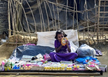 Una niña Rohingya se pinta los labios mientras espera a clientes en un puesto ambulante en el campo de redugiados de Kutupalong en el distrito de Ukhia (Bangladés).