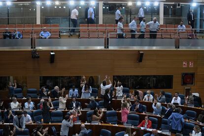 Varios diputados de Podemos y Más Madrid en la Asamblea de Madrid aplauden a miembros del sector del taxi en el pleno.