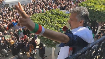 El empresario y activista argelino Rachid Nekkaz saluda desde un balcón mientras sotiene dos rosas, durante las protestas en Argel.