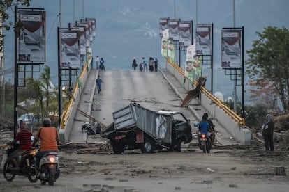 Un vehículo destrozado frente a un puente en Palu.