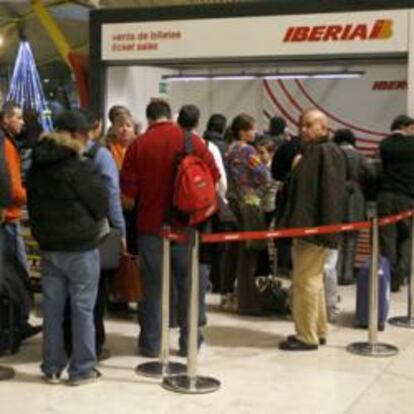 Un grupo de pasajeros frente a un mostrador de Iberia