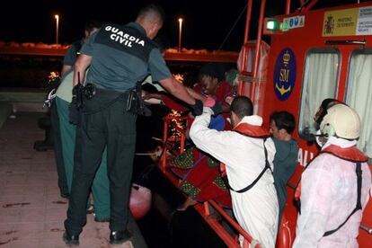 Agentes de la Guardia Civil ayudan a desembarcar a los inmigrantes subsaharianos en el puerto de Melilla, tras llegar al Pe&ntilde;&oacute;n de Alhucemas.