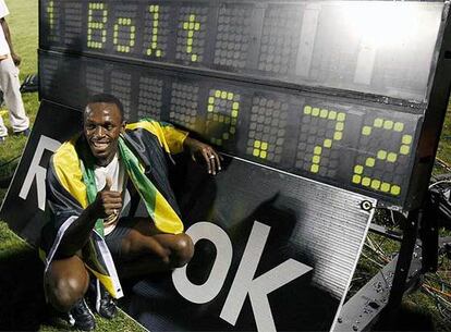 Bolt posa junto a su récord.