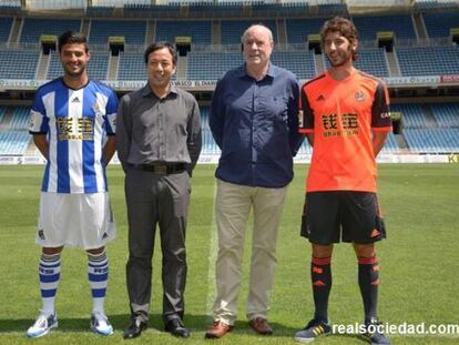 Los jugadores Carlos Vela y Esteban Granero junto a los propietarios de Qbao en la presentación de esta mañana.