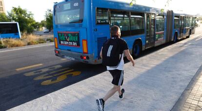 Un usuario corre para coger un autobús de la EMT, en Madrid.