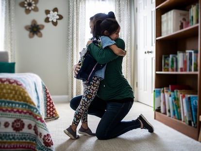 Una madre abraza a su hija antes de ir al cole.