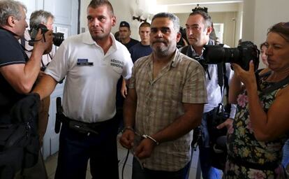 La policia escorta un dels detinguts per la mort a Àustria de 71 persones asfixiades a l'interior d'un camió.