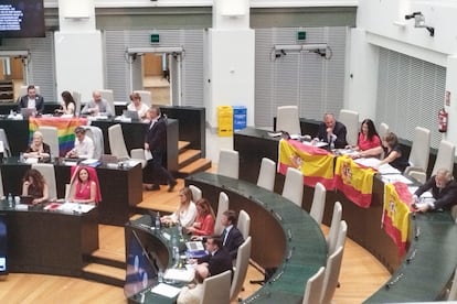 Los ediles socialistas despliegan en su bancada una bandera arcoíris y Vox contesta con tres banderas españolas, en el pleno municipal celebrado este martes en Madrid.