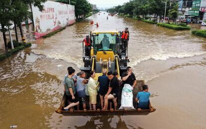 <b>Desastres que van más allá.</b> Las inundaciones en la China interior durante el verano no son raras. Durante milenios, las crecidas del Yangtzé o del río Amarillo fueron tan necesarias como temidas; al tiempo que fertilizaban los campos de una China abrumadamente rural, también destruía las viviendas y pertenencias de los campesinos. La urbanización y la construcción de presas pareció domarlos. Pero de manera creciente, este tipo de desastres meteorológicos parece ir a más: el año pasado, el desbordamiento del Yangtzé provocó las peores inundaciones desde 1998. La agencia meteorológica china ha atribuido las lluvias de esta semana a las corrientes de viento y la aproximación del tifón Infa, que desplazaron hacia Henan una gran cantidad de vapor de agua que se condensó en sus montañas. En la imagen, el personal de emergencia traslada a vecinos de Xinxiang por una calle inundada, el 23 de julio. <b>Macarena Vidal Liy (Pekín)</b>